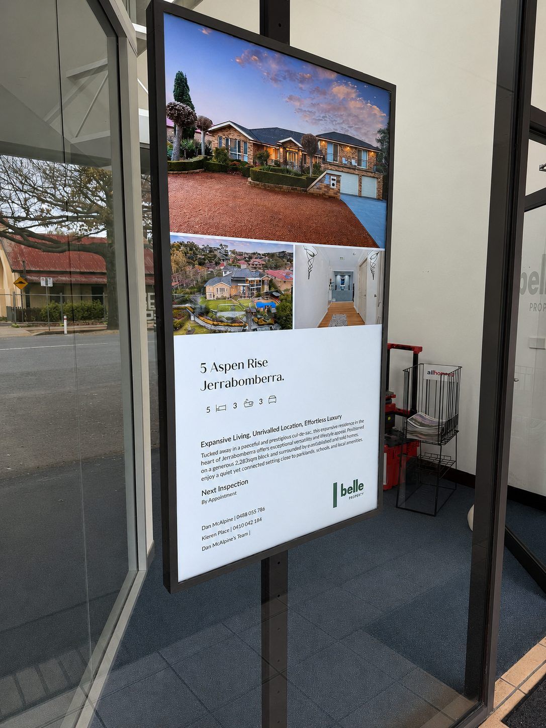 Finished front-facing view showing the digital signage display in operation within a glazed shopfront.