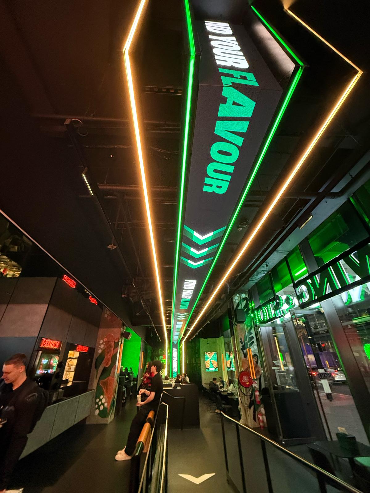 Ceiling-mounted LED ribbon feature extending through the venue to create a high-impact digital focal point.