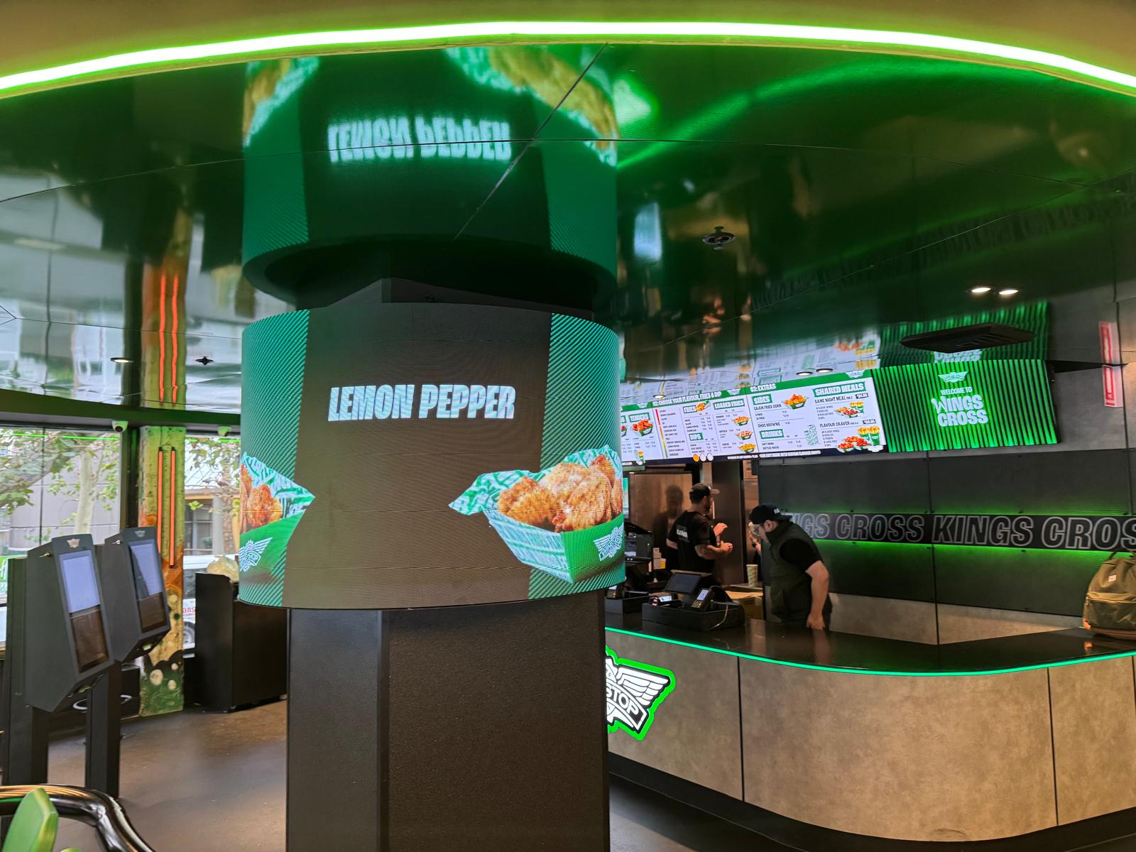 Curved LED display wrapped around a central structural column, used for dynamic branded content and promotions.