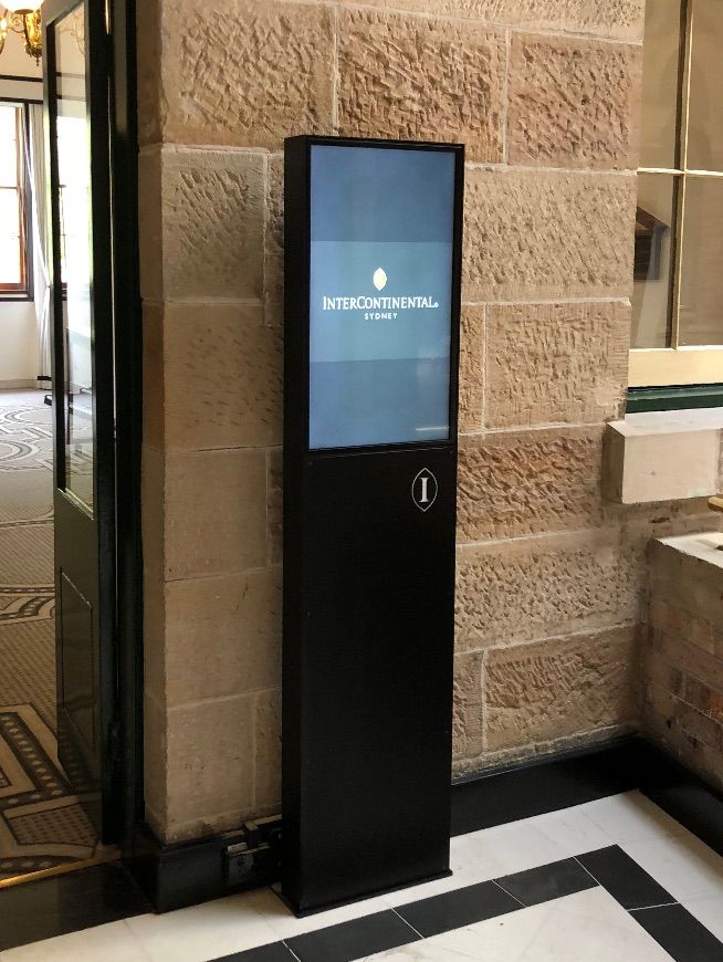 Freestanding hotel digital signage kiosk integrated into the venue architecture for guest information and wayfinding.