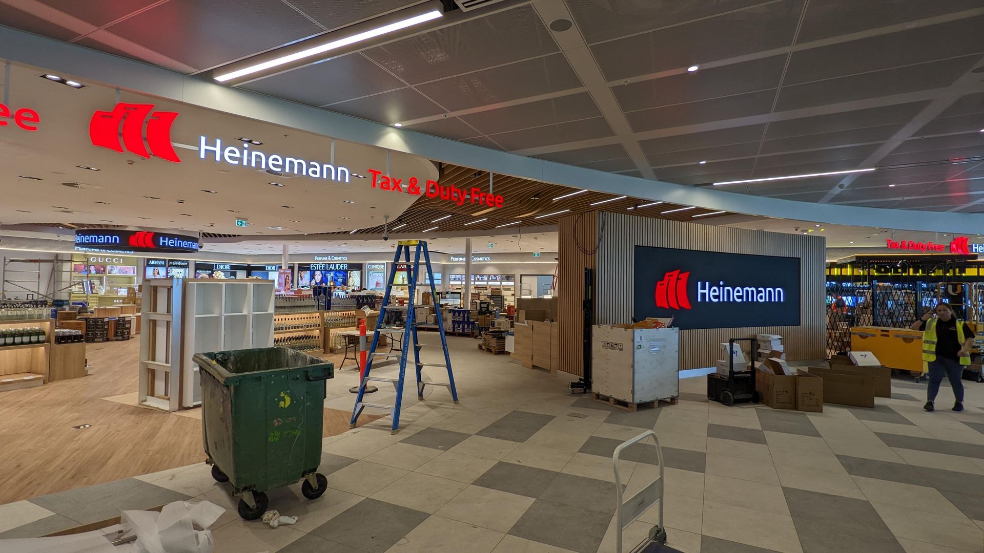 Large-format LED wall being installed above a duty-free retail fit-out, mid-construction.