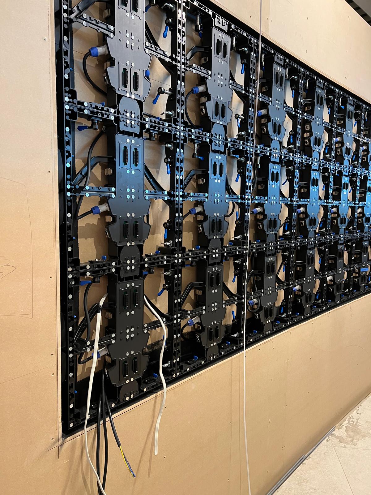 Close-up of the LED module rack, connectors and cable routing behind one of the display panels before final wiring.
