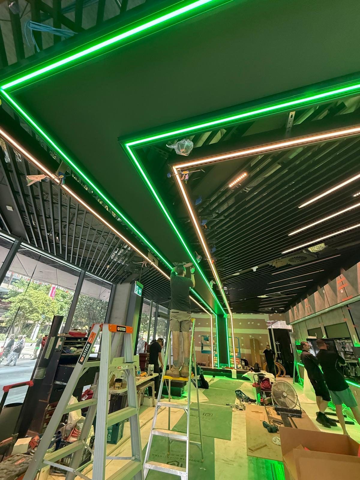 A closer view of the same LED ribbon ceiling feature, showing the framing and cable runs supporting the finished light strip.